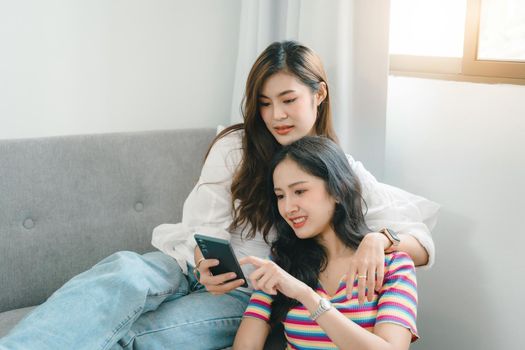 lgbtq, lgbt concept, homosexuality, portrait of two asian women enjoying together and showing love for each other while using smartphone mobile to take selfies.