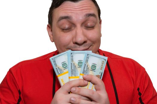 A happy man inhales the aroma of cash while holding it in his hands. Concept of financial success