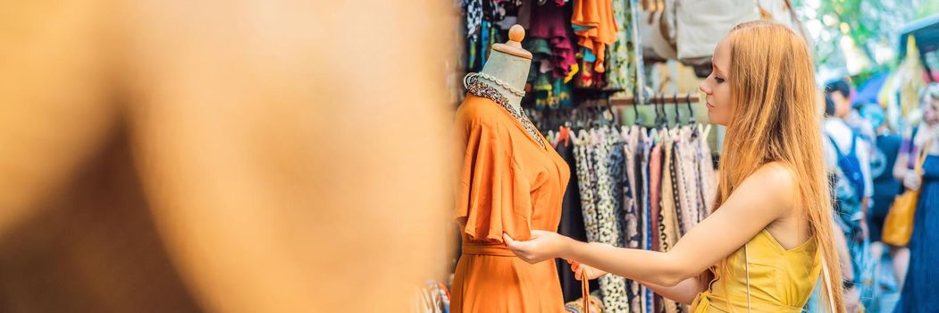 Woman traveler choose souvenirs in the market at Ubud in Bali, Indonesia. BANNER, LONG FORMAT