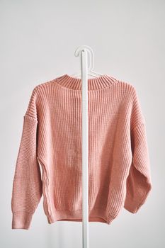 A woolen sweater hanging on a hanger on a white background. Warm clothes sale. Concept - everything is sold out in a clothing store.