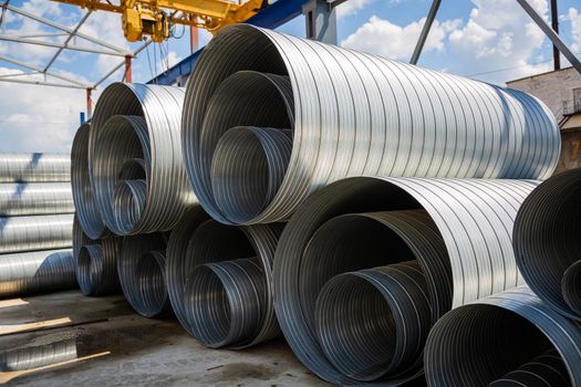 Ventilation pipe warehouse. Steel pipes, parts for the construction of air ducts for an industrial air conditioning system in a warehouse. Industrial airway ventilation equipment and piping systems.