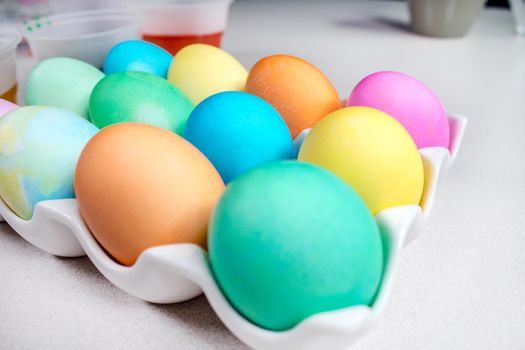 Pastel Easter eggs lying on white table. Traditional decoration