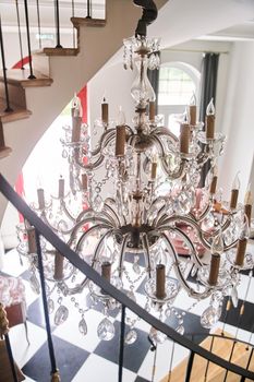 Old luxury chandelier in the interior. Designer lamp. High-quality photo