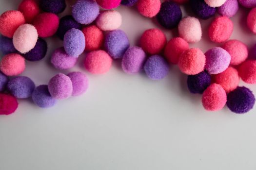 close up colorful pom poms texture background, heap of small pastel color fluffy ball for crafts and fashion accessories decoration, selective focus