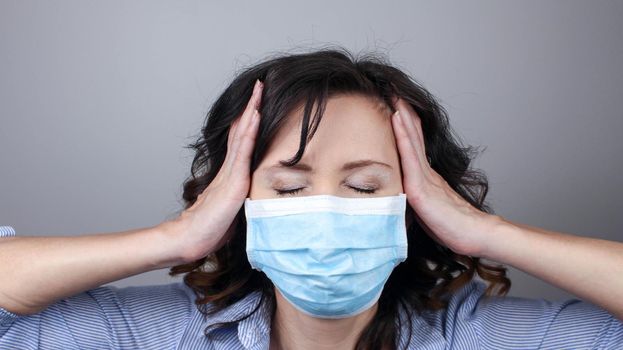 Woman wearing protection face mask against coronavirus. Cannot hear. Woman in a mask closing her ears. Medical mask, Close up shot, Select focus, Prevention from covid19