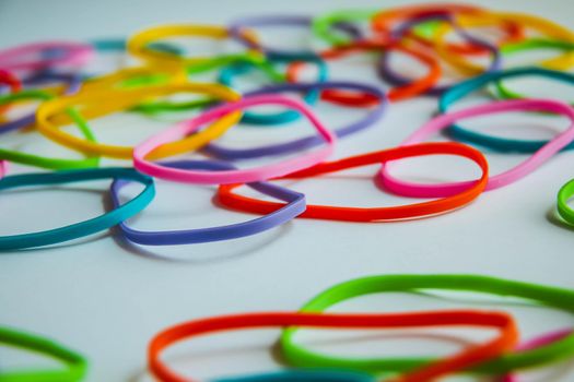 Side view of colorful rubber bands on white. Rainbow elastic rubber bands on white.