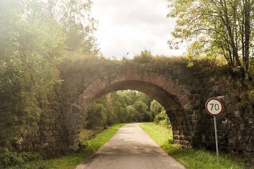 Old German bridge across the road. The bridge of the Rominten Forest. Vishtynetskoe lake. Kaliningrad region.