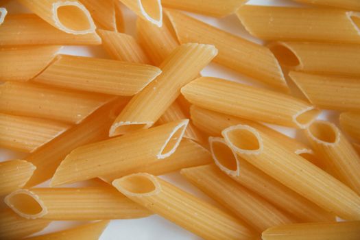 Raw macaroni on white. Dry noodles. Uncooked pasta. White background