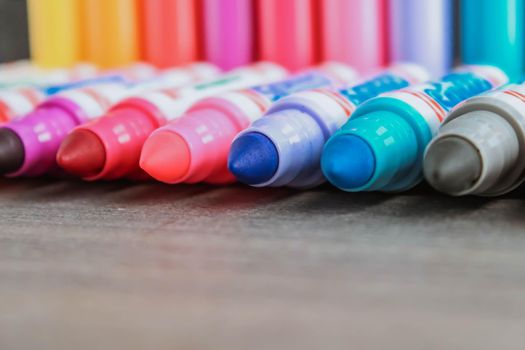 Colorful rainbow markers with blurred dark background