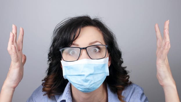 Woman wearing protection face mask against coronavirus and misted glasses. Woman in a mask looking shocked with hands up or worried. Medical mask, Close up shot, Select focus, Prevention from covid19