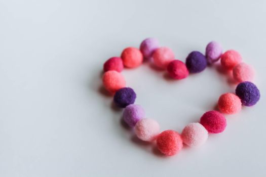 A beautiful big heart made of soft pom-poms against a light background. Heart love, love background, place for text