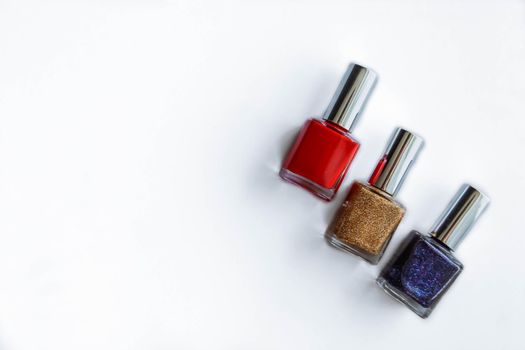 Colorful nail polish bottles on white. Red, gold, purple