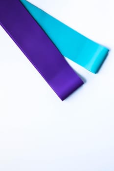 Fitness elastic band, elastic extenders of different colors for sports, isolated on a white background.