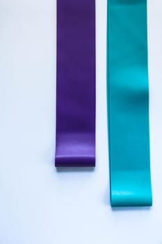 Fitness elastic band, elastic extenders of different colors for sports, isolated on a white background.