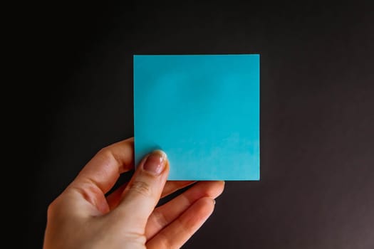 Hand with colorful notes on black background