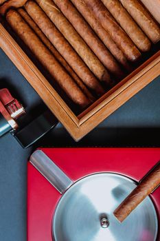 View of cigars in humidor and ashtray. Flat lay