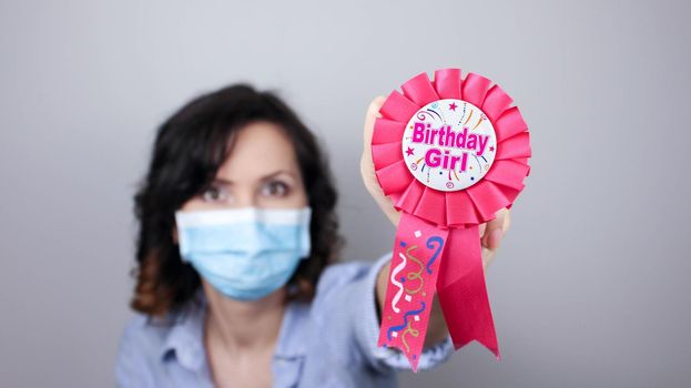 Woman wearing protection face mask against coronavirus. Woman in a mask with party supply. Birthday girl. Medical mask, Close up shot, Select focus, Prevention from covid19