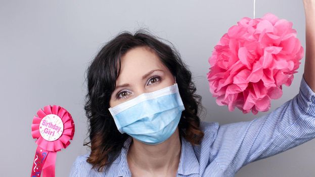 Woman wearing protection face mask against coronavirus. Woman in a mask with party supply. Birthday girl. Medical mask, Close up shot, Select focus, Prevention from covid19