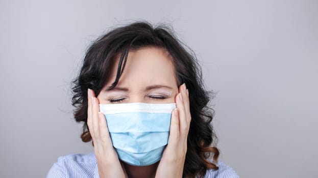 Woman wearing protection face mask against coronavirus. Woman in a mask looking shocked or worried with hands up. Medical mask, Close up shot, Select focus, Prevention from covid19