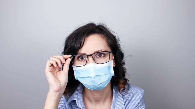 Woman wearing protection face mask against coronavirus. Woman in a mask and glasses. Medical mask, Close up shot, Select focus, Prevention from covid19