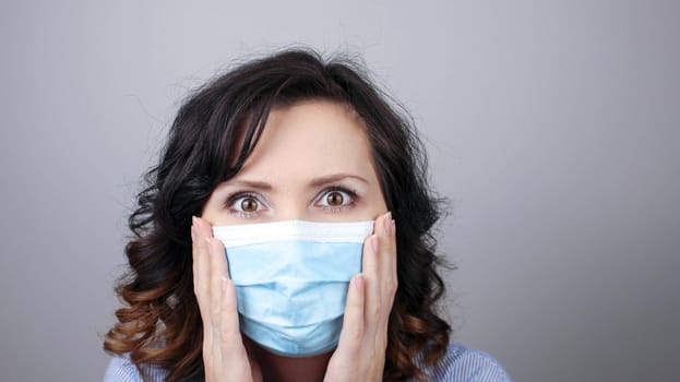 Woman wearing protection face mask against coronavirus. Cannot hear. Woman in a mask closing her ears. Medical mask, Close up shot, Select focus, Prevention from covid19