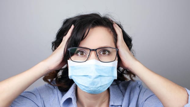 Woman wearing protection face mask against coronavirus. Cannot hear. Woman in a mask closing her ears. Medical mask, Close up shot, Select focus, Prevention from covid19