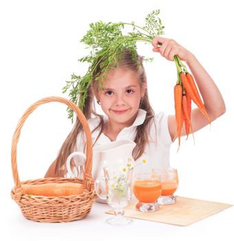 Nice blond baby girl with glass of carrot juice