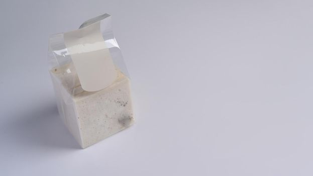 Moldy bread in package on white background.