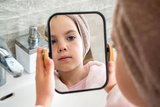 Relaxed young girl model wears towel wrapped on head, feels refreshed after taking shower, has healthy clean soft skin, poses in cozy bathroom. Girl, beauty and hygiene concept. High quality photo