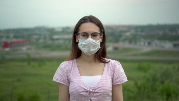 Young woman wearing glasses wearing a medical mask. 4k