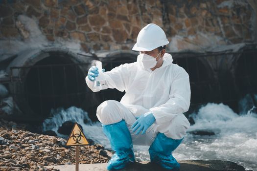 Ecologist sampling water from river with test tube glass and have white smoke, Biologist collects sample waste water from industrial of toxic chemicals, scientist environmentalist, problem environment