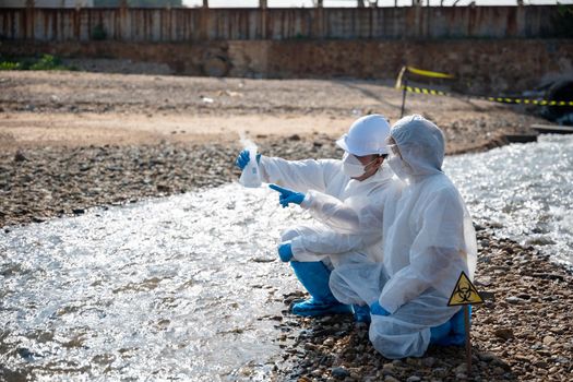 Ecologist sampling water from river with test tube glass and have white smoke, Biologist collects sample waste water from industrial of toxic chemicals, scientist environmentalist, problem environment