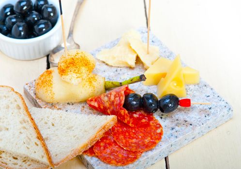 cold cut assortment cheese salami and fresh pears served on a granite stone