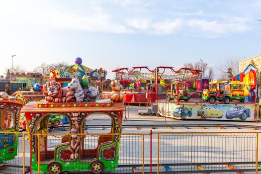 Children's rides and carousels are closed and empty. Joy and entertainment for children. Bright carousels and carriages for transporting children are empty. Carousels are waiting for children.