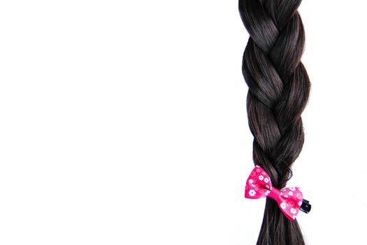 Black braided hair isolated on white background. Brunette natural braided hair extension on white background