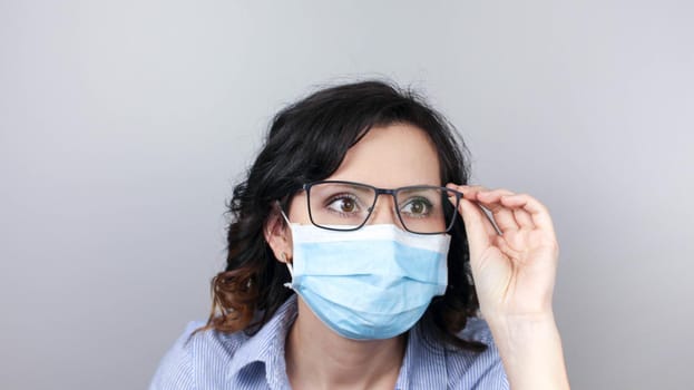 Woman wearing protection face mask against coronavirus. Woman in a mask and glasses. Medical mask, Close up shot, Select focus, Prevention from covid19