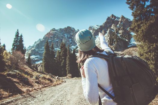 A young woman points the way to the top of the mountain. Shows the direction.