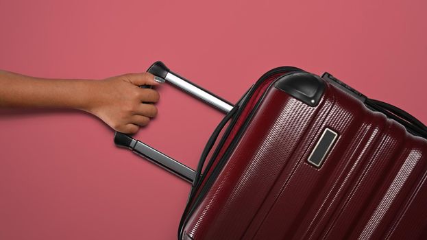 Woman with suitcase on pink background, ready for summer holidays. Top view with copy space.