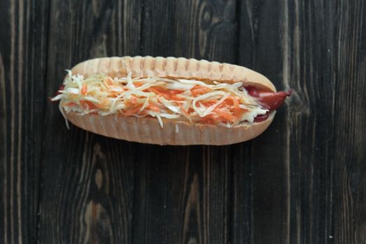 hot dog with vegetables on wooden background.photo with copy space.
