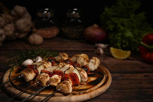 Close up tasty grilled chicken skewers with tomato, sweet pepper and onions on cutting board ready to serve.
