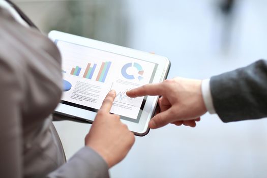 close up. colleagues discuss financial data using a digital tablet.