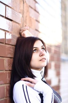 portrait of cute young woman on brick wall background.