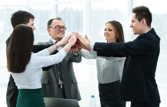 close up.boss and business team joining hands together.the concept of teamwork