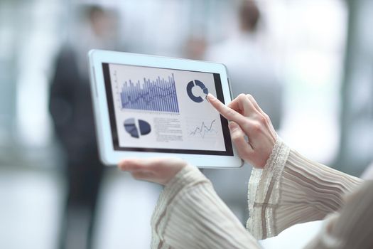 close up.a business woman points her finger at the financial chart.