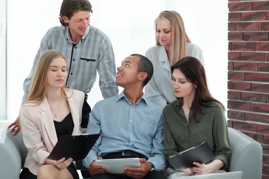business woman and her business team discussing the data with a tablet computer.the concept of teamwork