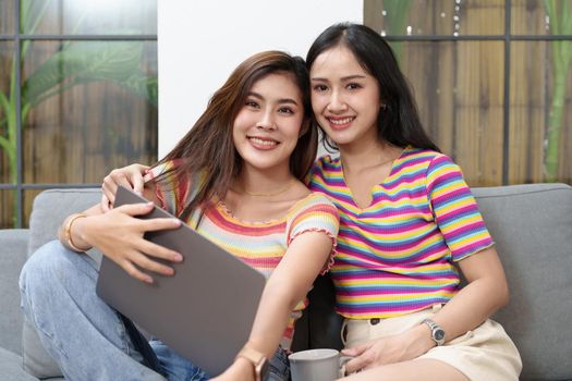 lgbtq, lgbt concept, homosexuality, portrait of two asian women posing happy together and loving each other while playing computer laptop on bed.