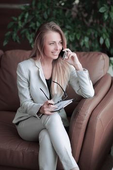 close up.business woman with clipboard talking on the phone.photo with copy space