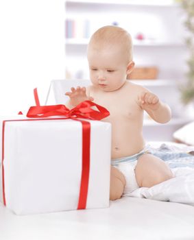 surprised baby playing with gift boxes