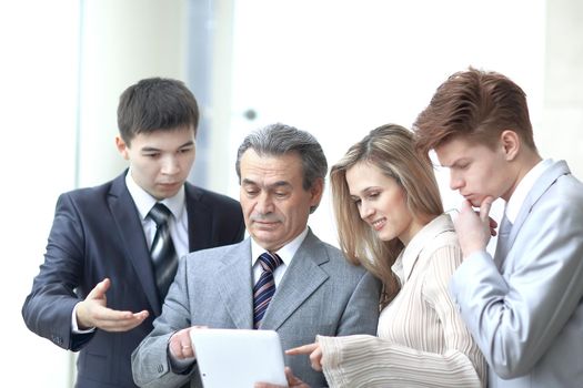 businessman and his team look at the screen of the digital tablet.