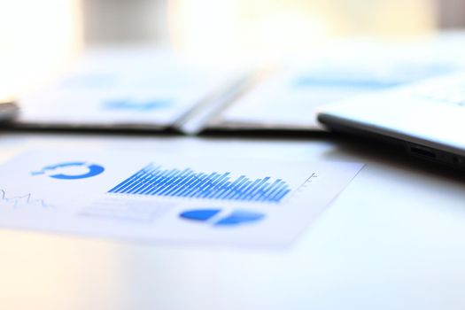 bokeh business background. office working place. laptop,financial schedule and pencil